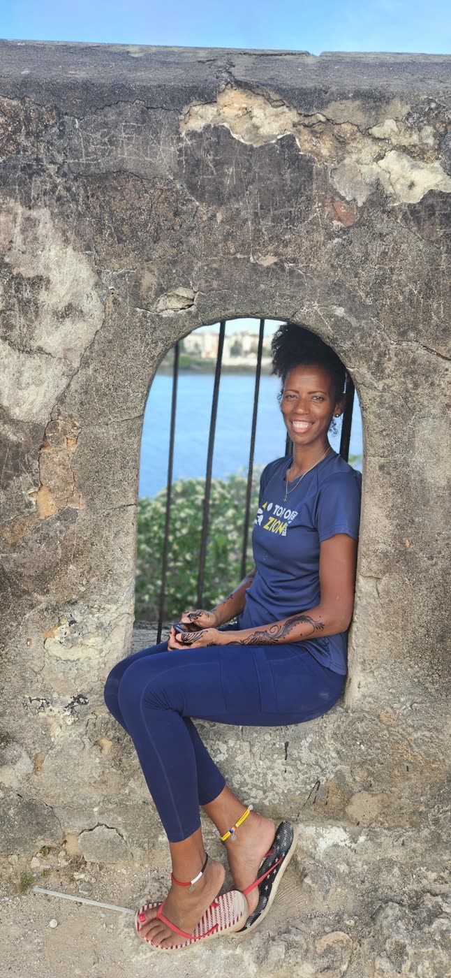A traveler sitting in an old coral-stone archway