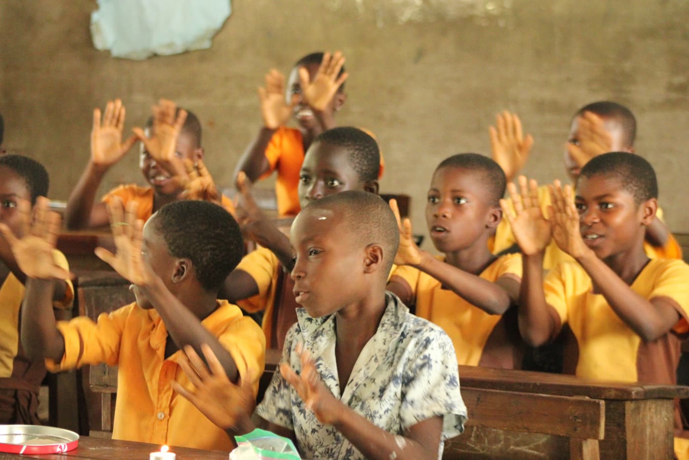 Students clapping and smiling in class in Ghana