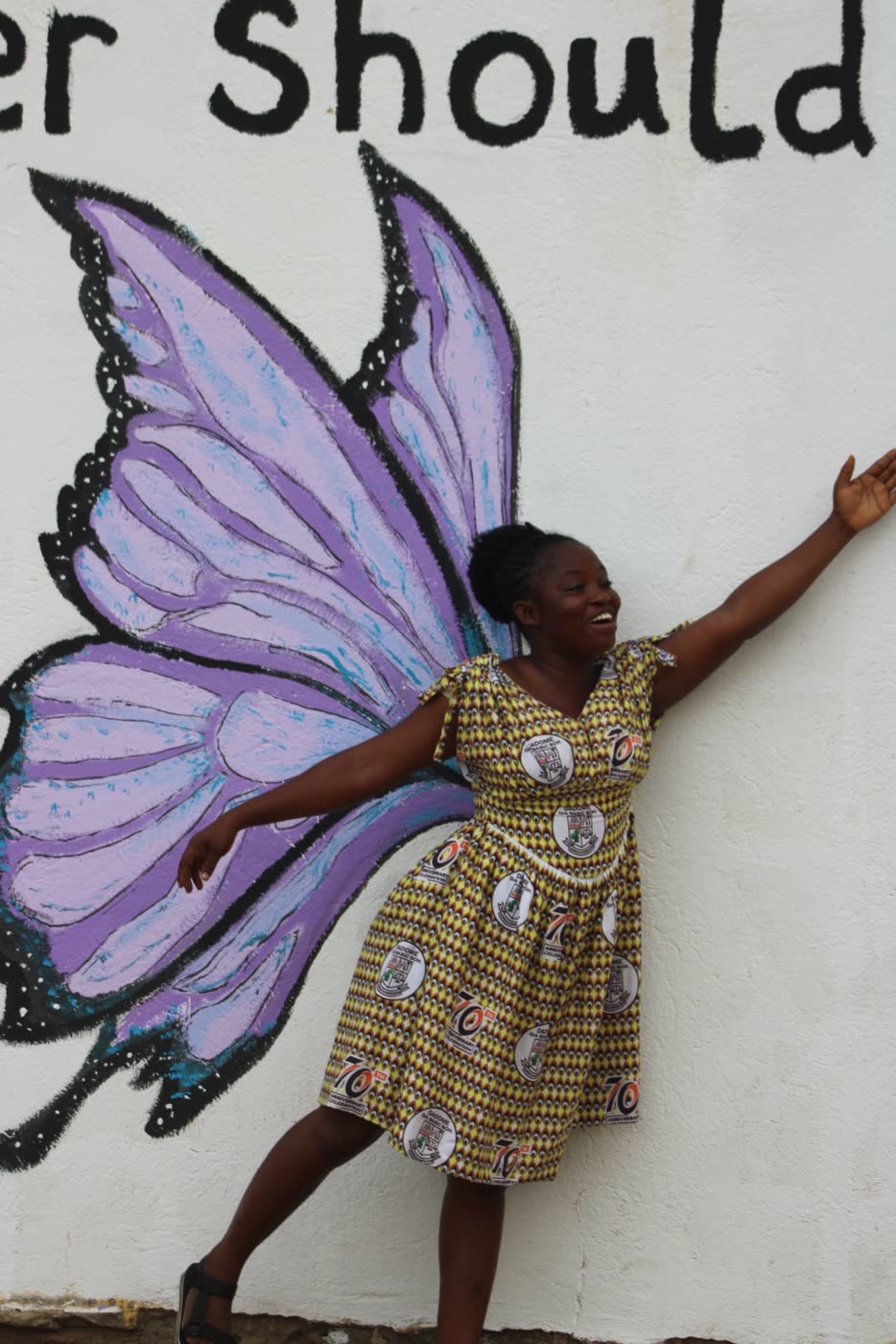 A student with the butterfly wings mural